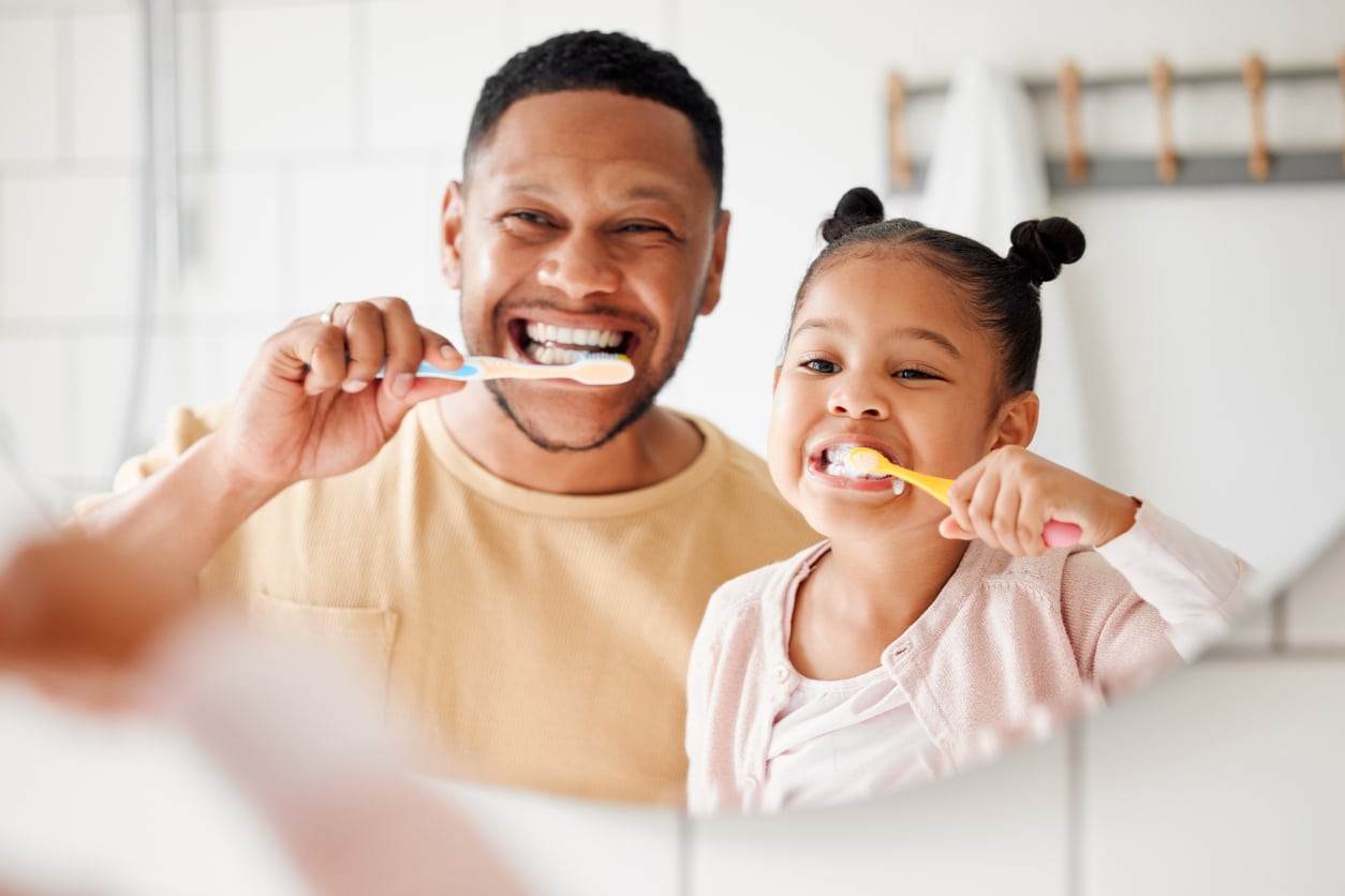 a young boy brushing his teeth with a toothbrush in his mouth