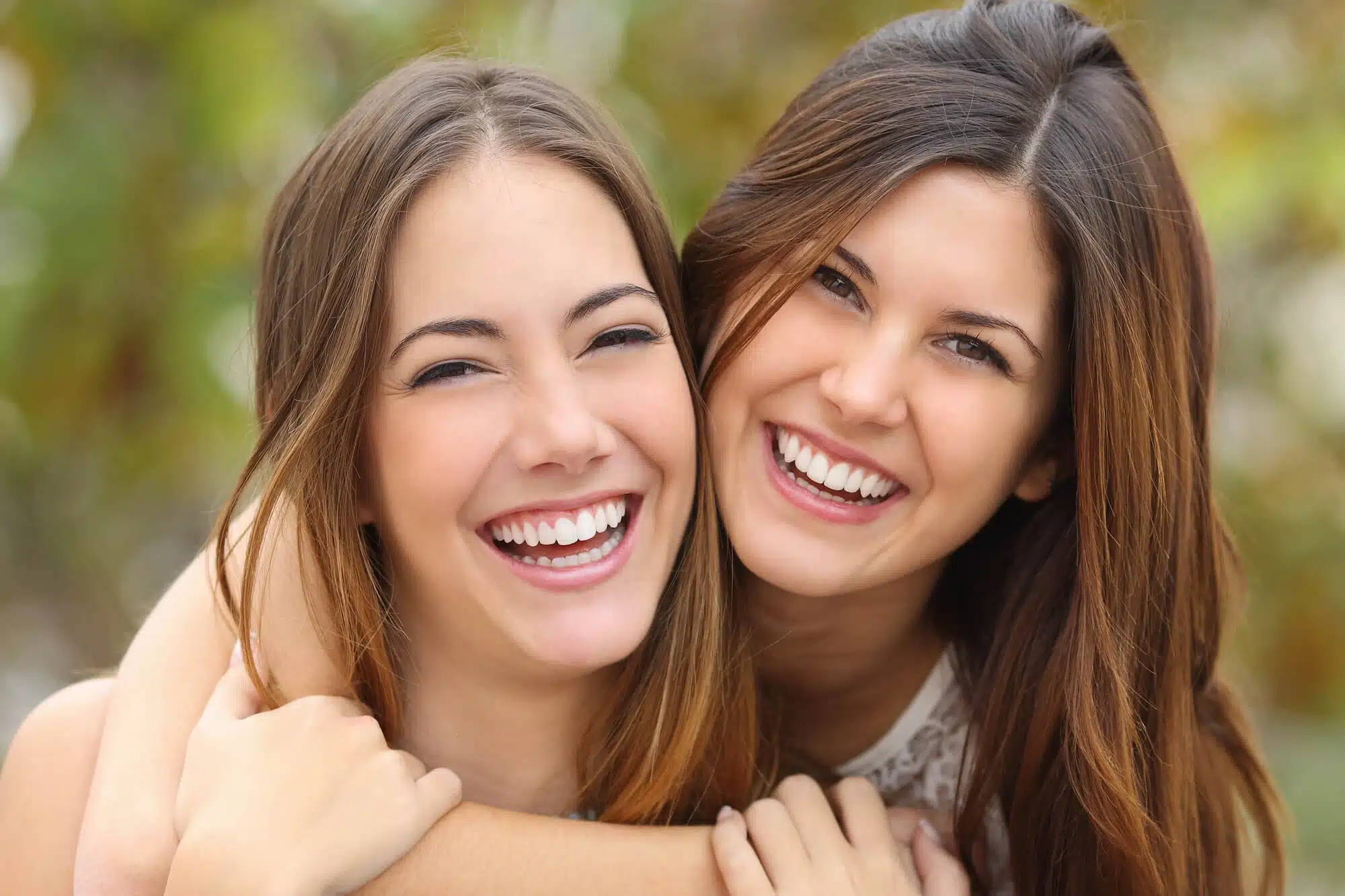 Sisters smiling after treatment with a brownstown cosmetic dentist